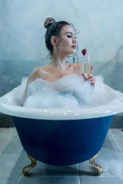 Bella femmina con champagne fare il bagno — Foto Stock