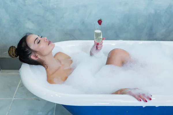 Mooie dame met Champagne genieten van schuimige bad — Stockfoto