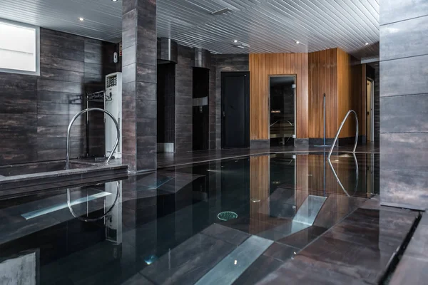 Temiz su havuzu ve kaplıca salonunun duvarları olan şık bir oda.