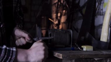 Parlak kıvılcımlarla eski makasları keskinleştiriyor