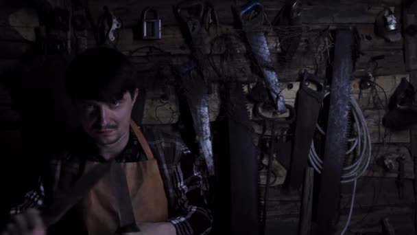 Loco maníaco enojado agudiza cuchillos oxidados en una casa vieja — Vídeos de Stock