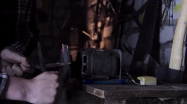 Parlak kıvılcımlarla eski makasları keskinleştiriyor