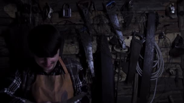 Un fou fou furieux aiguise des couteaux rouillés dans une vieille maison. espace de copie — Video