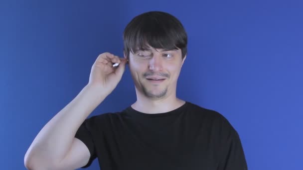 Man cleans his ears with a cotton swab and enjoys — Stock Video