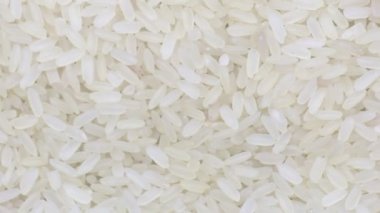Çiğ pişmemiş pirinç uzun tahıl yakın plan dönüyor.