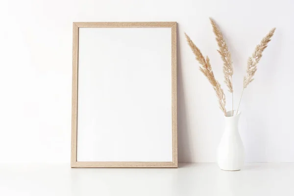 Wooden frame mockup on white table with vase — Stock Photo, Image