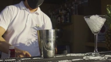 Güneşli bir günde içki hazırlayan bir barmen.