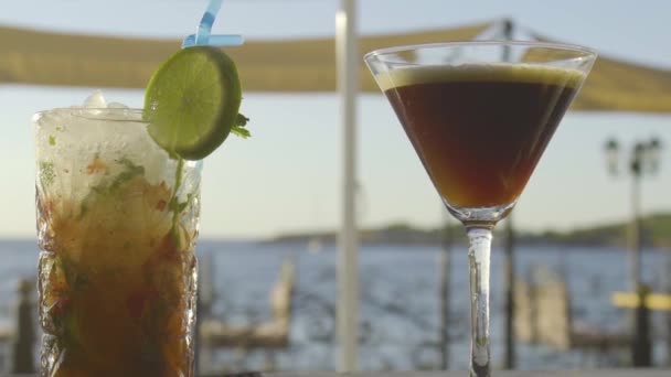 Långsam mo av cocktails på en bar med solnedgång i bakgrunden — Stockvideo