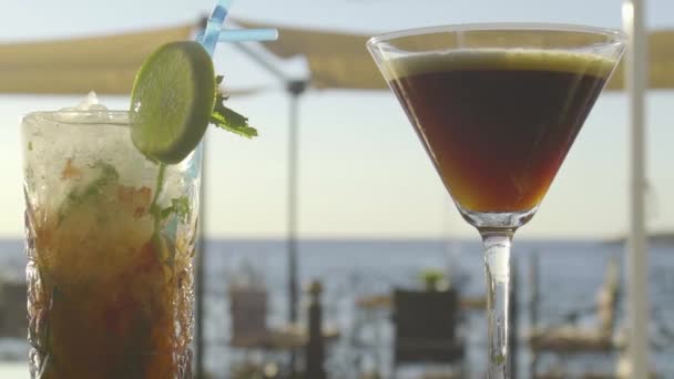 Långsam mo av cocktails på en bar havet horisont i bakgrunden — Stockvideo