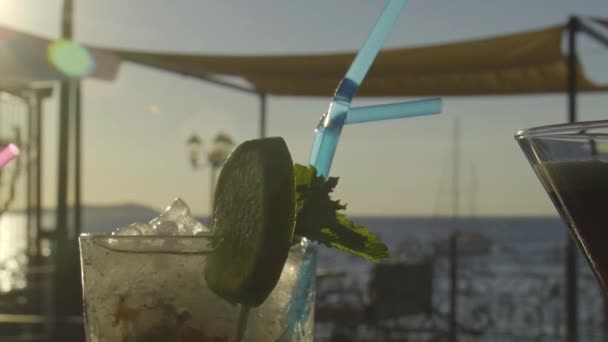 Långsam mo av cocktail på en bar med solnedgång i bakgrunden — Stockvideo