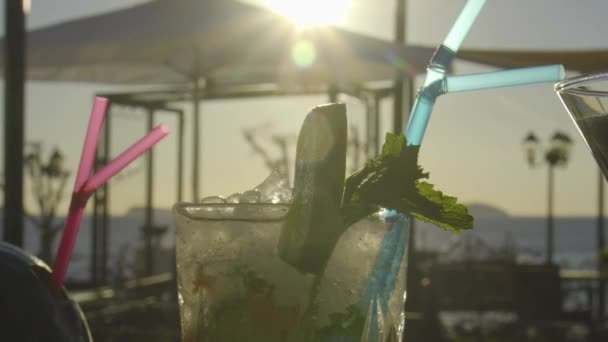 Медленный снимок коктейля на баре с закатом на заднем плане — стоковое видео