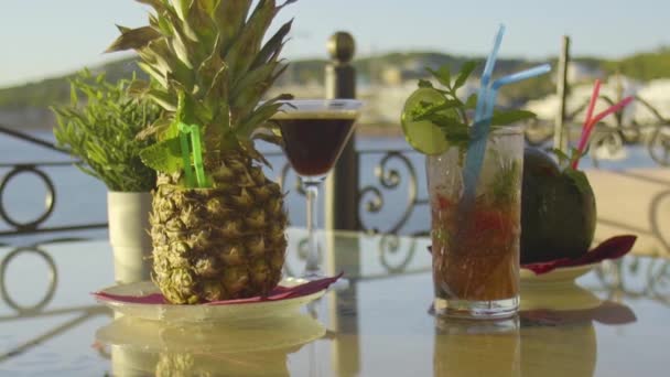 Sunlit cokctials på ett bord med havet i bakgrunden — Stockvideo