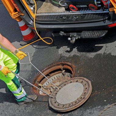 Kanalizasyon kapağı sokakta çalışan kapatır