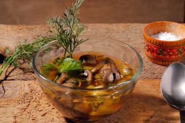 Bir cam kabın içinde ahşap arka plan üzerinde mantar çorbası