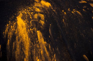 Siyah bir zemin üzerine sarı toz boya.