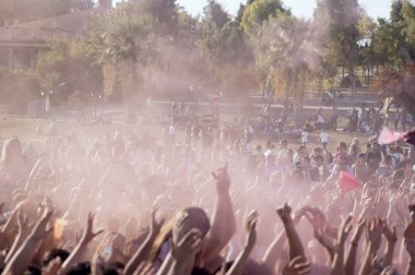 Izmir, Turkey - October 15, 2017: Crowded people at Colored Powder Paint festival at Izmir Buca Golet. Buca municipality performs this event every year. Izmir Turkey. clipart