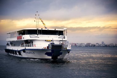 Izmir, Türkiye - 28 Ekim 2018. Vapur Ege ve Izmir yolcularla defne ve bulutlu gün batımı.