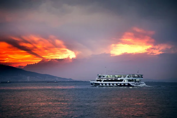 Izmir, Türkiye - 28 Ekim 2018. Vapur Ege ve Izmir yolcularla defne ve bulutlu gün batımı.