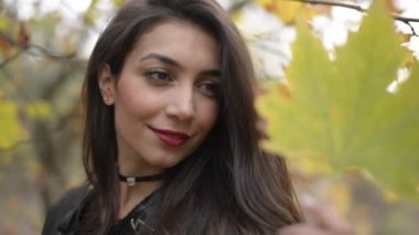 Sonbahar sezonu ve doğada bir kuru yaprak ile poz bir Orta Doğu kadın.