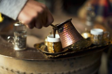 Bir bakır cezve gelen sıcak kum altın Türk kahvesi bardak pişmiş hizmet veren Türk kahvesi.