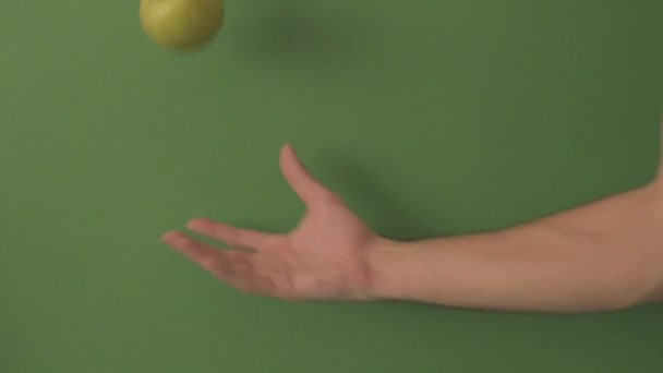 Caucásico Mano Masculina Rebotando Una Manzana Verde Sobre Fondo Verde — Vídeo de stock