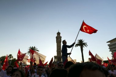 Izmir, Türkiye - 15 Haziran 2018: Demokrasi Türkiye'de Izmir'in 15 Haziran günü. Türk bayrakları Konak, Izmir tarihi saat kulesi önünde kare holding ve insanlar.