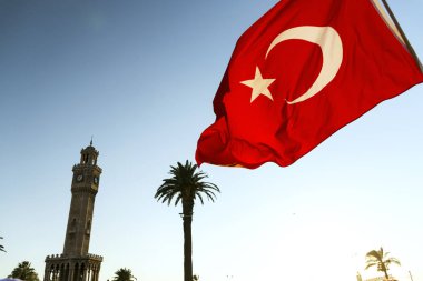 Izmirs Saat Kulesi ve Türk bayrağı sallayarak ile palmiyeler.