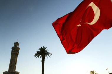 Izmirs Saat Kulesi ve Türk bayrağı sallayarak ile palmiyeler.