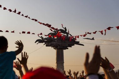 Izmir, Türkiye - 9 Eylül 2018. Cumhuriyet ağacı bayrakları ve Solo Türk ün hava gösterisi grubu ile. Izmir'in bağımsızlık günü kutlamaları için. Ferit Ozsen heykel sanatçısı.