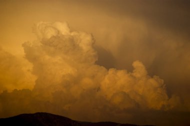 Dağların üzerinden bulutlar Cumulus türü kırmızı boyalı.