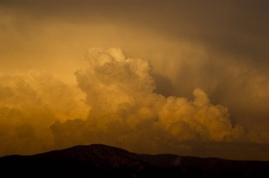 Dağların üzerinden bulutlar Cumulus türü kırmızı boyalı.