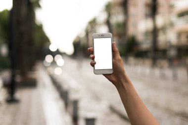 Sokakta bir akıllı telefon elinde boş ekran bakıyor.