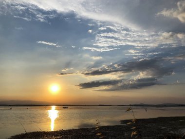 Bulutların üstünde günbatımı yapraklara ile.