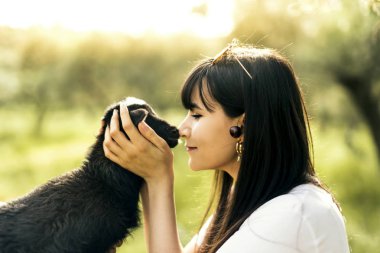 Beyaz gömlek ve siyah pantolon deri kemer ile beyaz beyaz kadınla ve siyah bir goatling sarılarak
