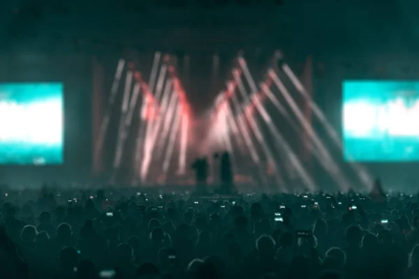 Concert field, crowded people and stage lights.