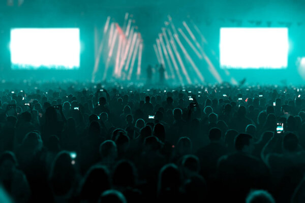 Concert field, crowded people and stage lights.