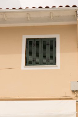 Yeşil perde kapalı pencere bej bir duvar.