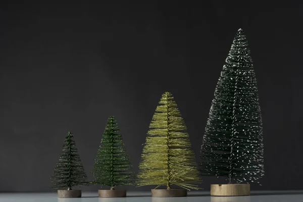 Four pine trees on a black background.