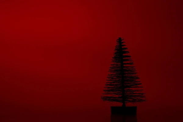Een Silhouet Kunstmatige Naaldboom Een Rode Achtergrond — Stockfoto