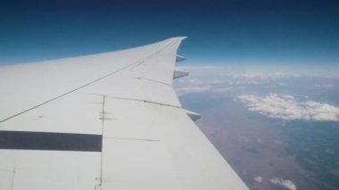 Uçaklar penceresinden bulutlar ve kanat.
