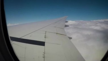 Bir uçak penceresinden Timelapse. Kanat ve bulutlar görüyoruz.