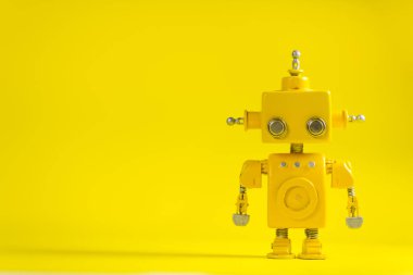 Şirin, sarı, el yapımı robot sarı bir arka plan üzerinde.