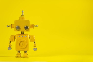 Şirin, sarı, el yapımı robot sarı bir arka plan üzerinde.