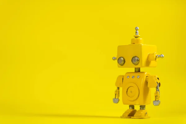 Cute, yellow, handmade robot on a yellow background.