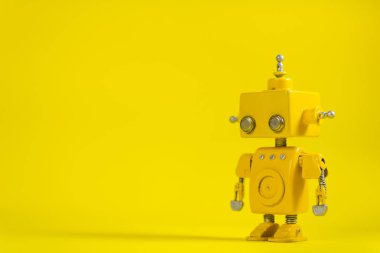 Şirin, sarı, el yapımı robot sarı bir arka plan üzerinde.