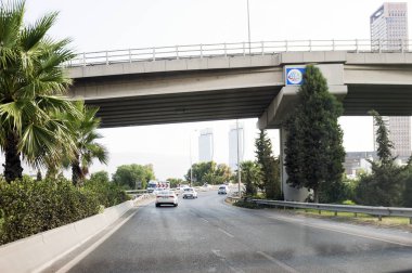 Izmir, Türkiye-8 Ağustos 2018: palmiye ağaçları ve Folkart kuleleri ve Altınyola yolu üzerinde bazı arabalar ile bir yol üzerinde köprü.