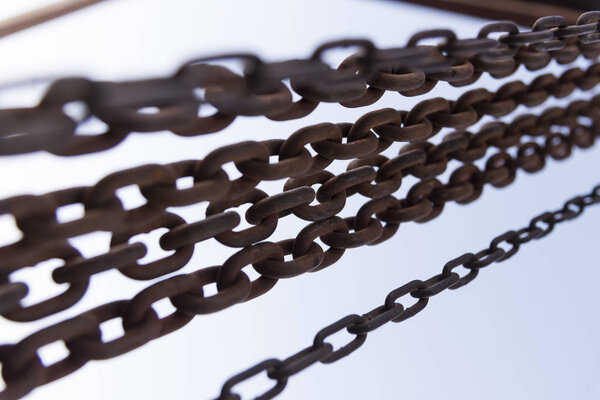 Ржавые цепи закрывают снимки на голубом фоне неба
.