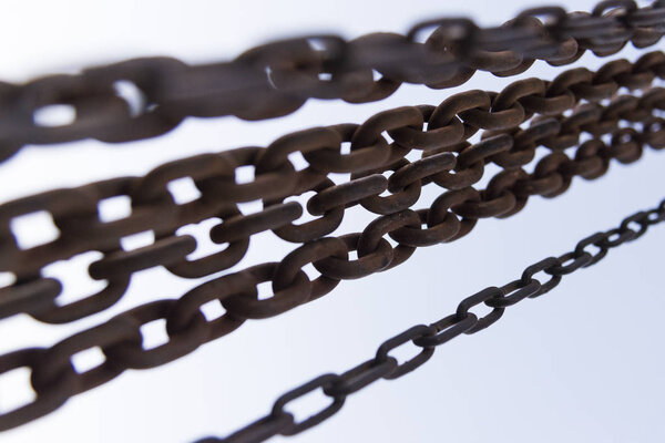 Ржавые цепи закрывают снимки на голубом фоне неба
.