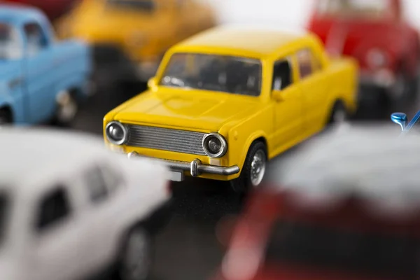 Ułożone zabawki samochody i model 70s żółty samochód zabawka w centrum uwagi. — Zdjęcie stockowe