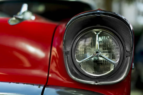 Cabeça do lado da frente ilumina um pára-choques de um Chevrolet de 1957 de cor vermelha — Fotografia de Stock